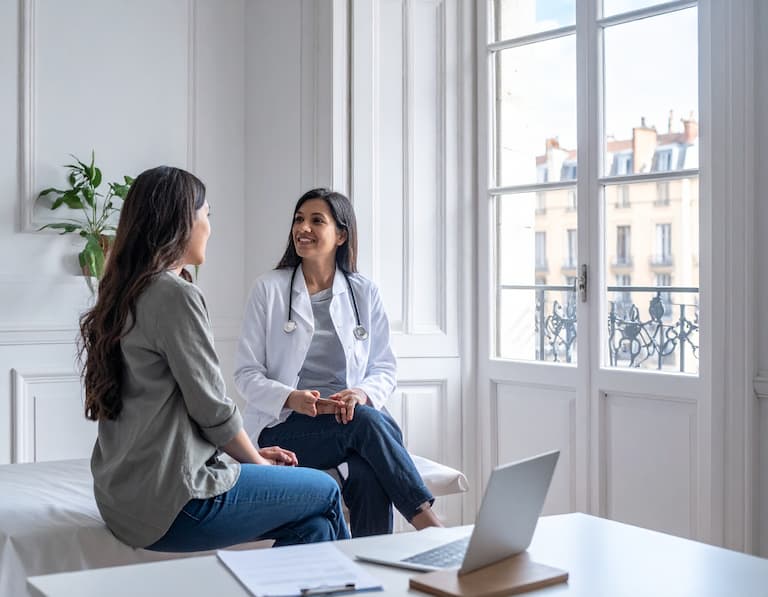 Une femme médecin généraliste en consultation dans un cabinet de style haussmannien typique du centre-ville de Lyon