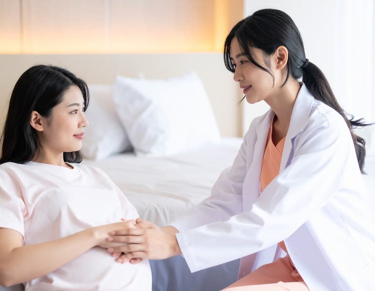 Une sage-femme apportant un soutien moral et physique à une future maman en salle de naissance